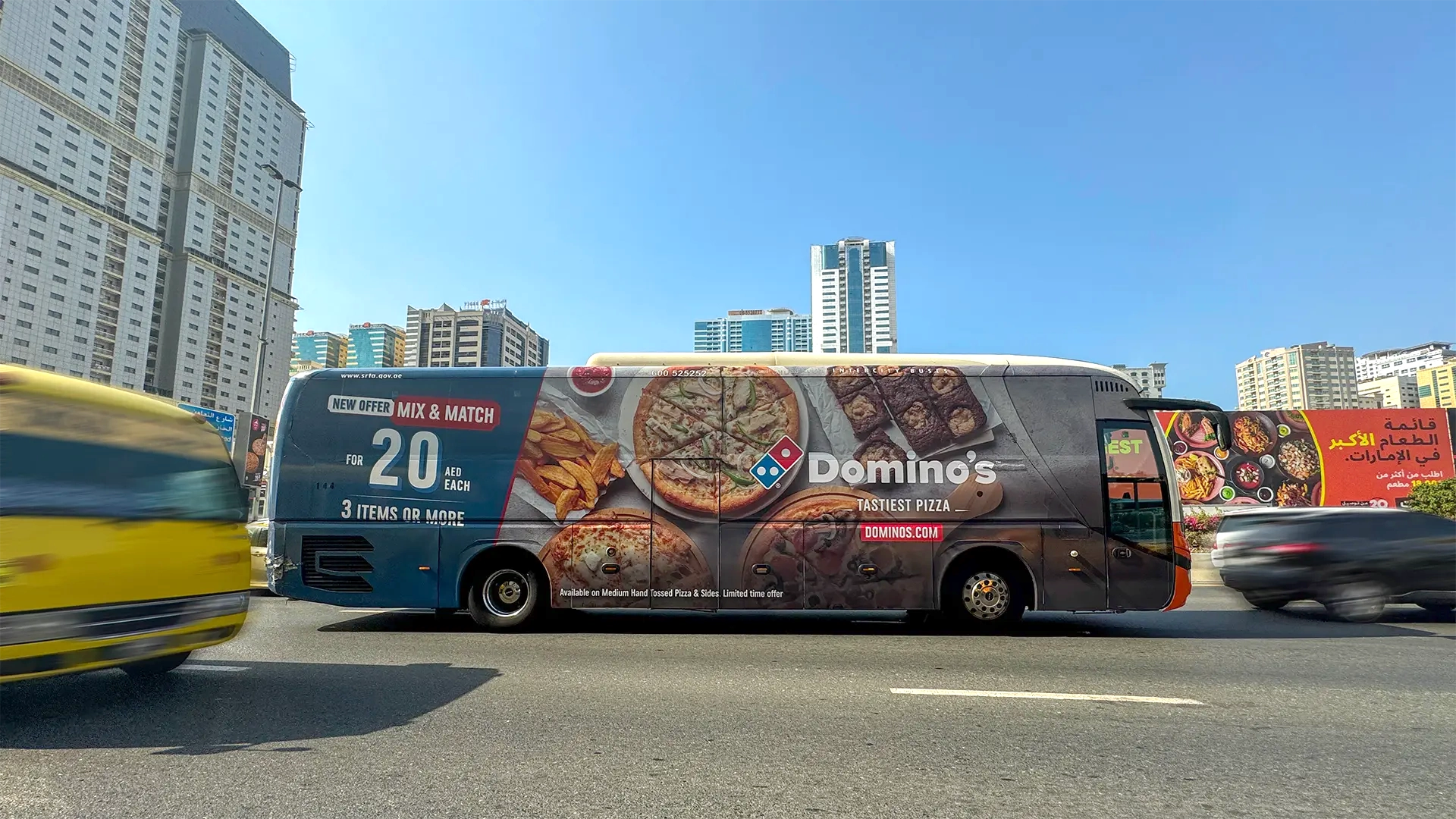 An RTA bus with a fully-wrapped Domino’s Pizza advert drives through Dubai