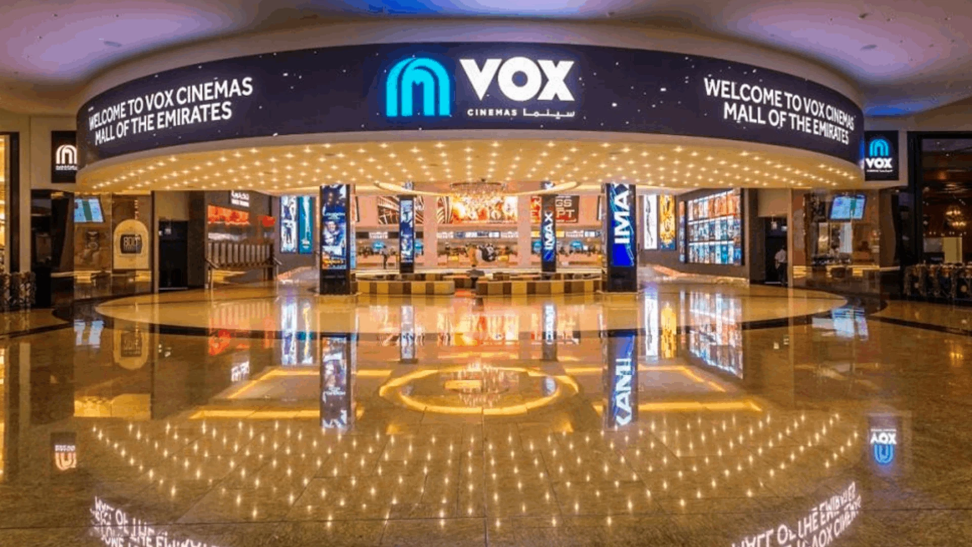 A wide-angle shot of a Dubai cinema with a branded screen ad