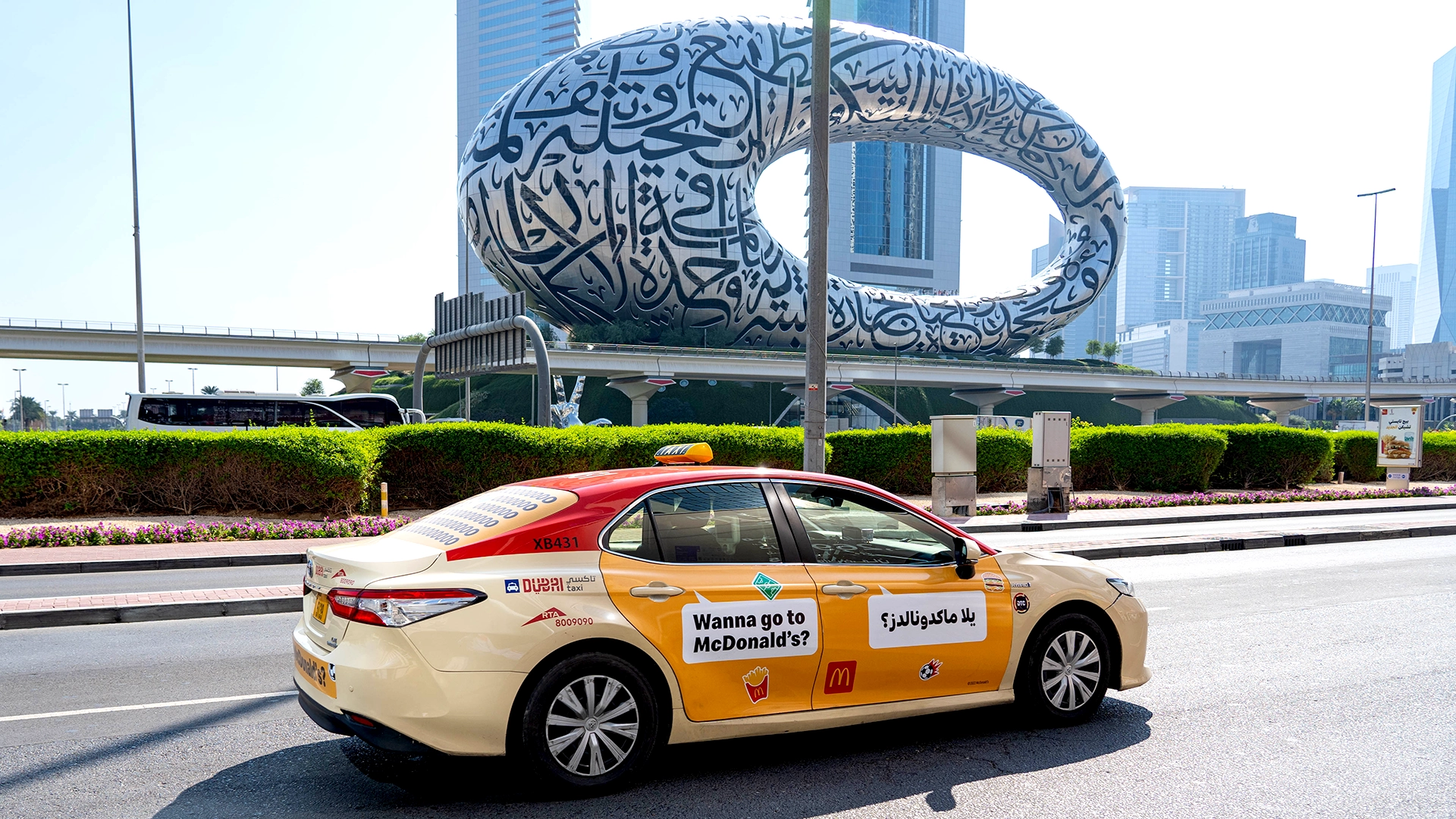 A taxi with McDonald’s branding drives along Sheikh Zayed Road past the Museum of the Future