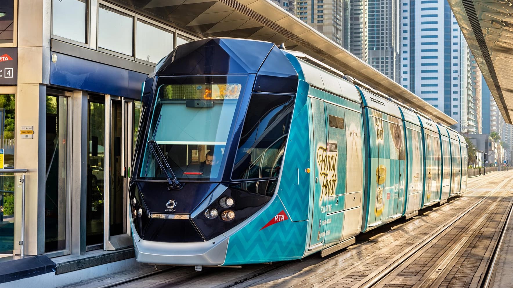 A fully wrapped tram for Fancy Feast cat food arrives at a Dubai Tram station