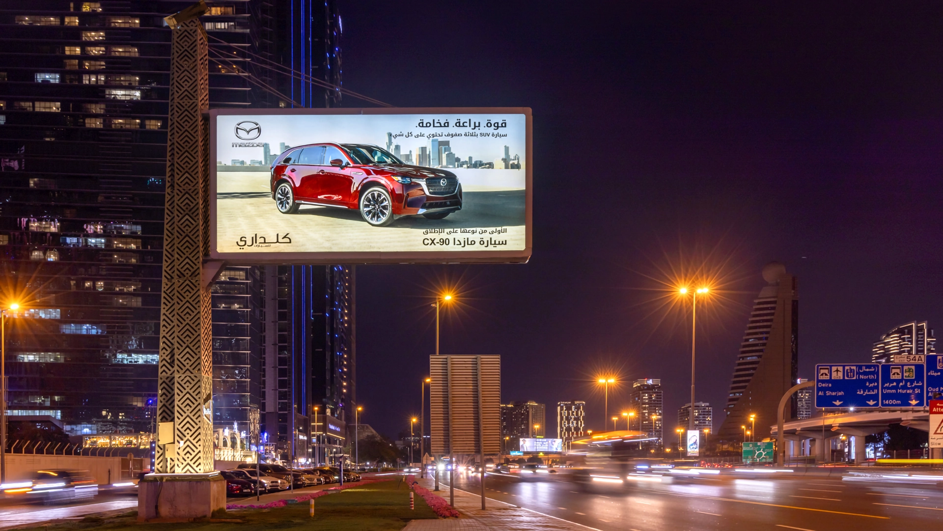 An advert with Arabic text for the Mazda CX-90 on Sheikh Zayed Road at night