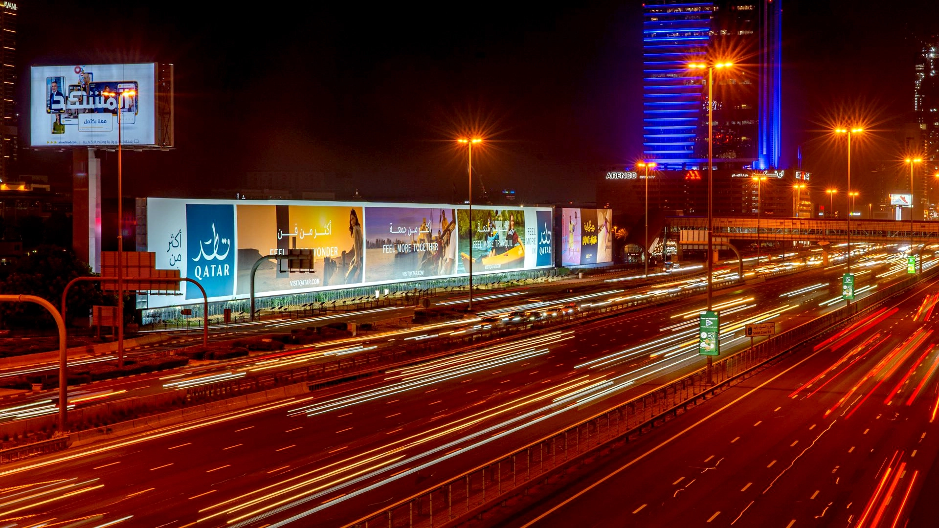 An advert for Qatar tourism shown on a mega billboard on Sheikh Zayed Road at night