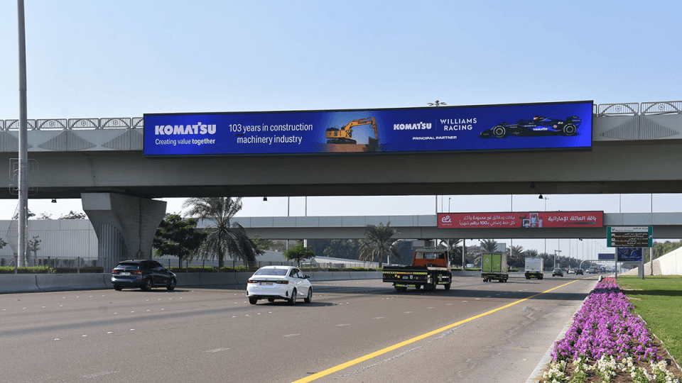 Bridge banner spanning Al Khail Road at dusk